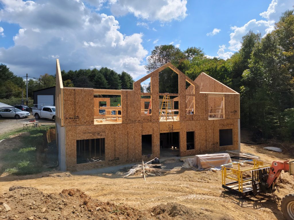 20231003_132312 Construction progress showing front SIP panel framing on concrete foundation, illustrating precision SIP assembly for mountain home build.