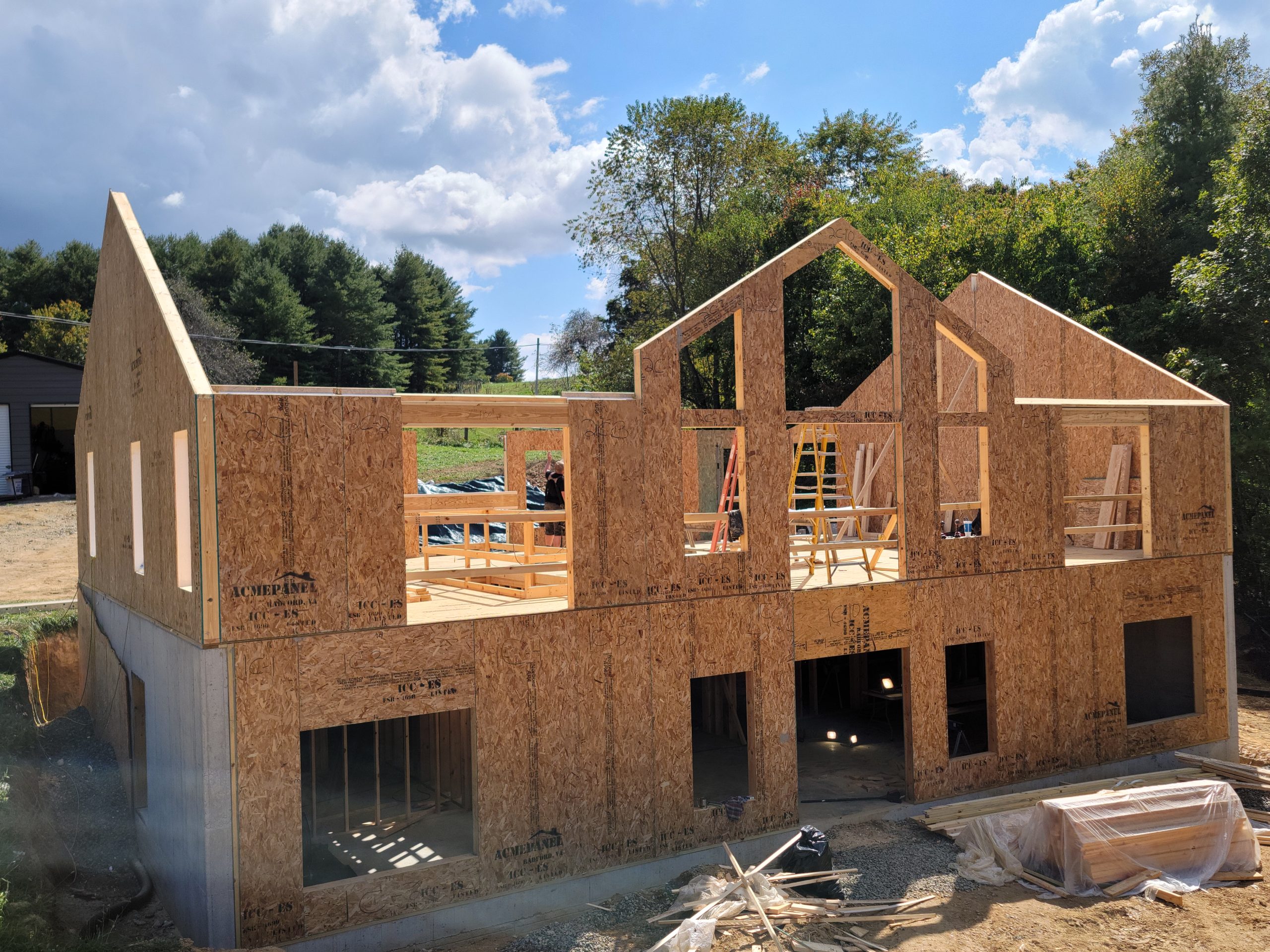 Structural insulated panel (SIP) installation during framing phase of energy-efficient mountain home, showing engineered wall and floor system layout