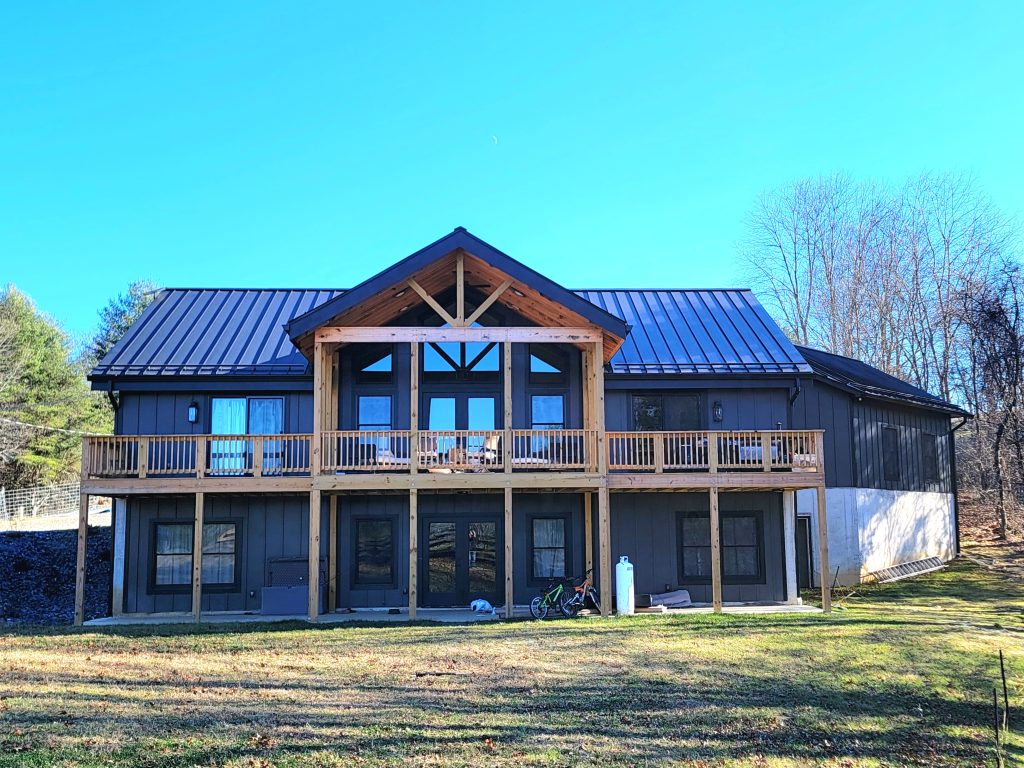 20241206_135949 Back view of completed SIP home with expansive timber deck and screened porch, structurally designed for mountain living and open views