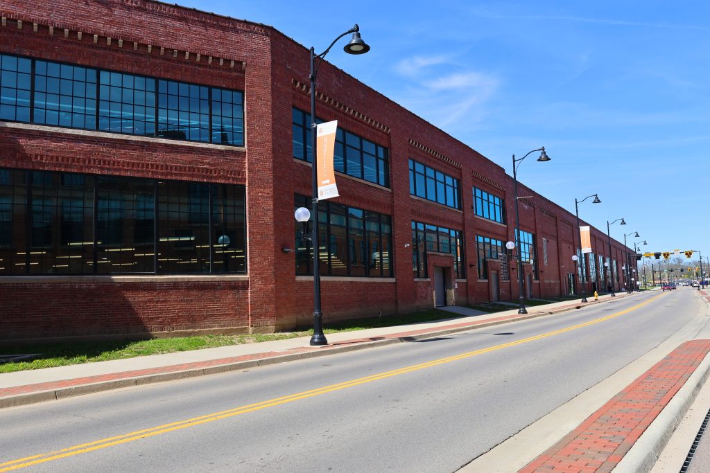 Spooky Hollow Hamilton OH back and street view Street view of Spooky Nook Sports' historic red brick industrial building in Hamilton, Ohio, showcasing large factory-style windows and vintage architectural charm.