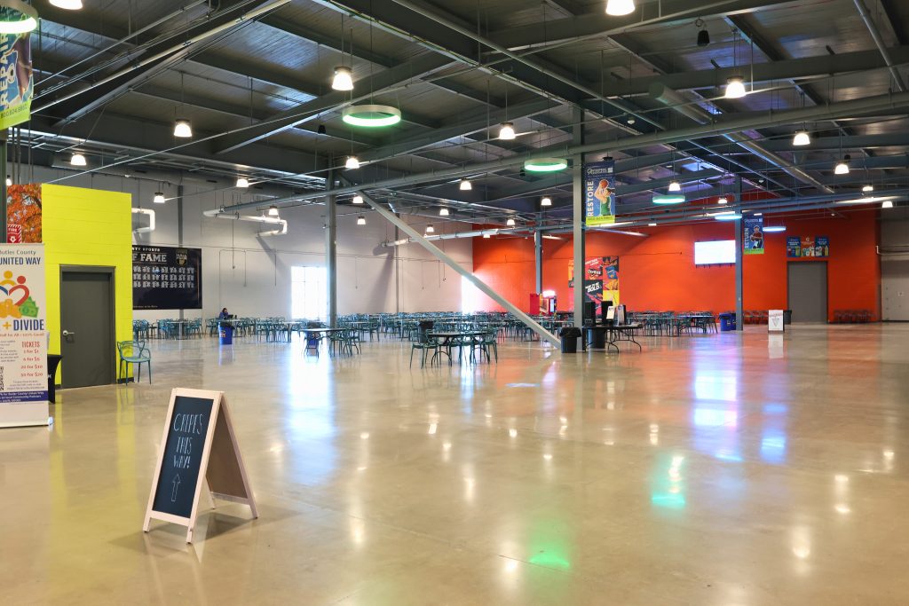 Spooky Nook Hamilton OH Food hall Large open dining area inside Spooky Nook Sports complex in Hamilton, Ohio, with cafeteria-style seating, colorful signage, and bright industrial lighting.