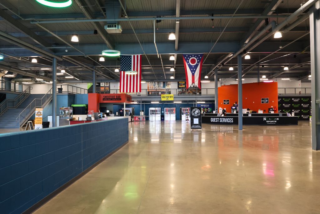 Spooky Nook Hamilton Oh Main Lobby Spacious main lobby at Spooky Nook Sports Champion Mill in Hamilton, Ohio, featuring guest services, smoothie bar, American and Ohio state flags, and modern industrial design.