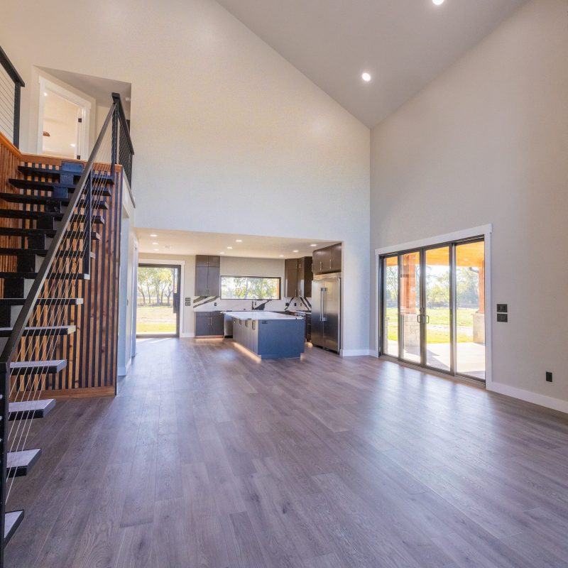 barndominium interior open floor plan with vaulted ceilings staircase and stone fireplace